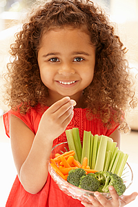 Young girl holding a bowl of vegetables